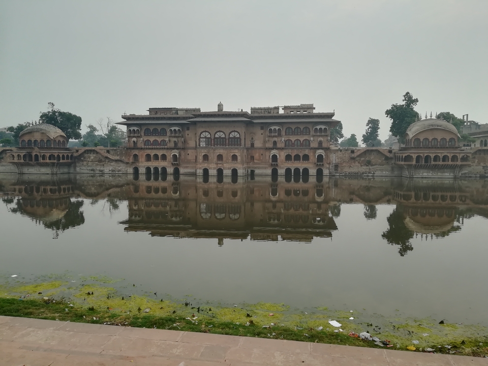 Historic building with domes reflected in a water body.
