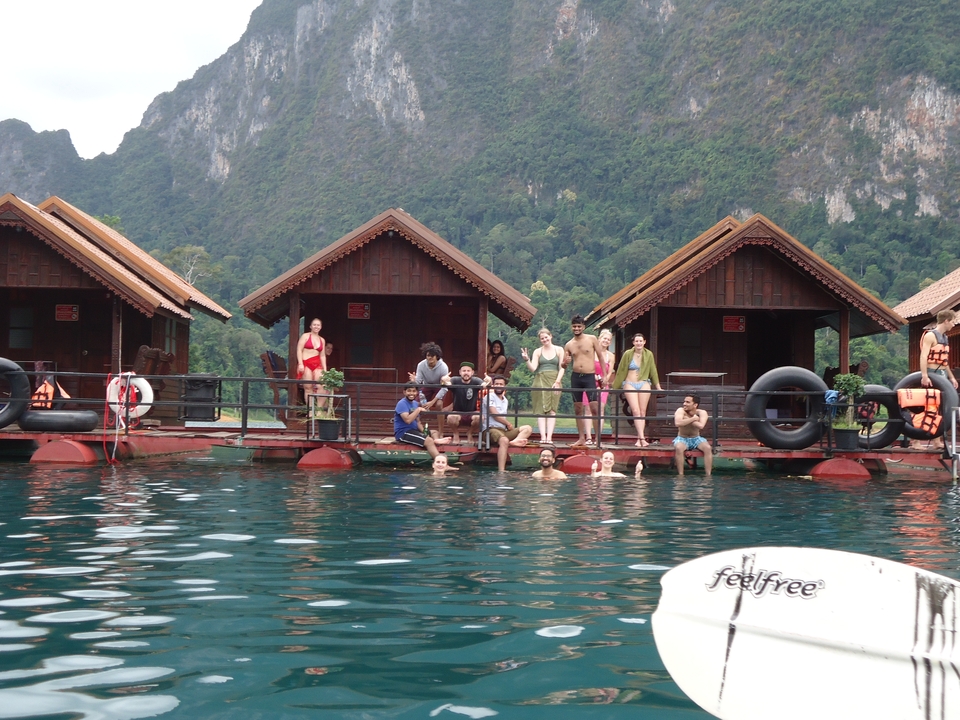 Group of people on floating bungalows in a lake.