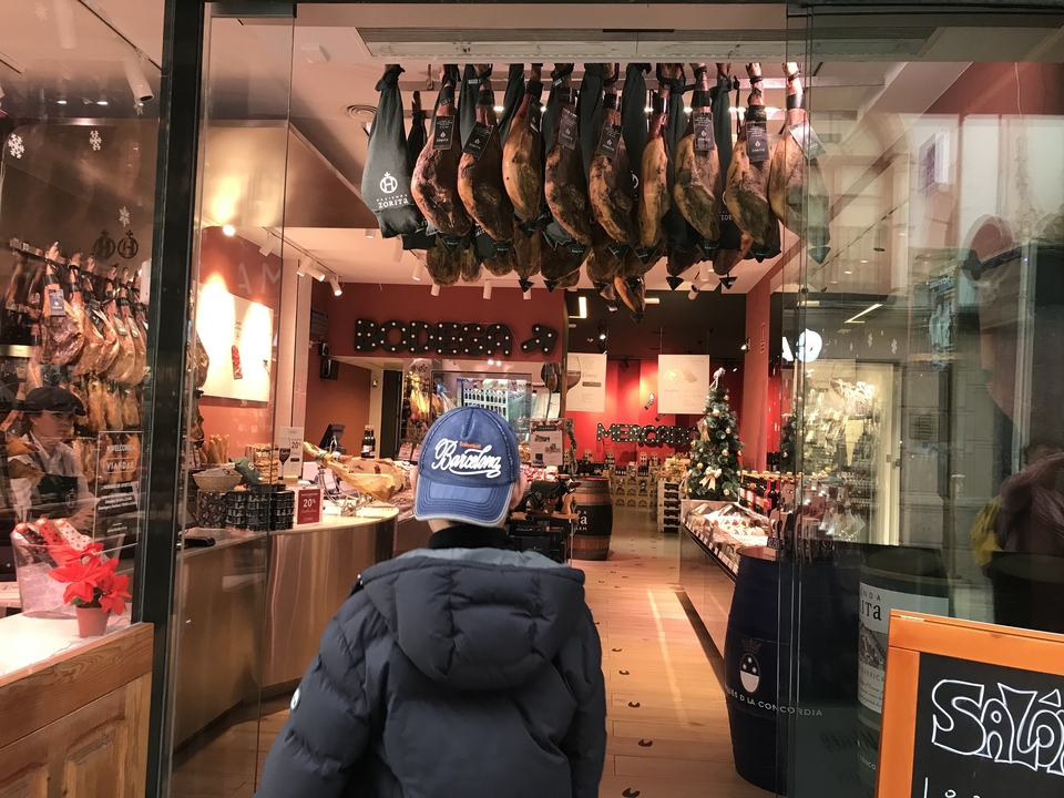Shop interior with a variety of hams hanging from the ceiling.