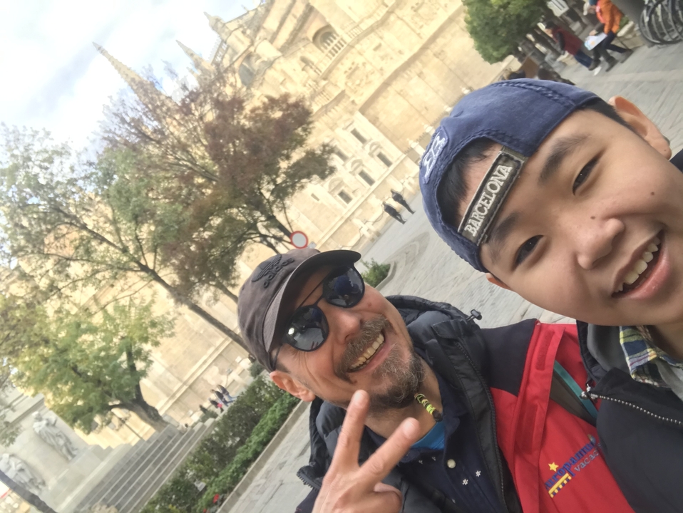 Two people taking a selfie with historical architecture in the background.