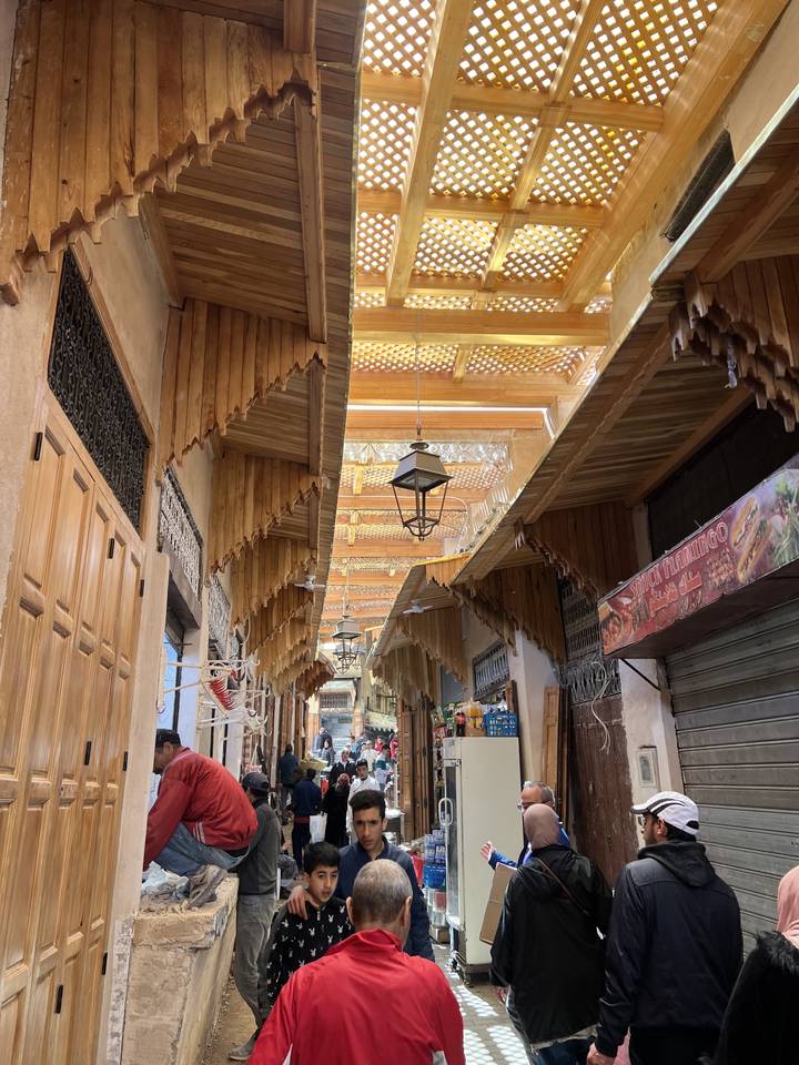 A bustling market street with people and wooden architecture.