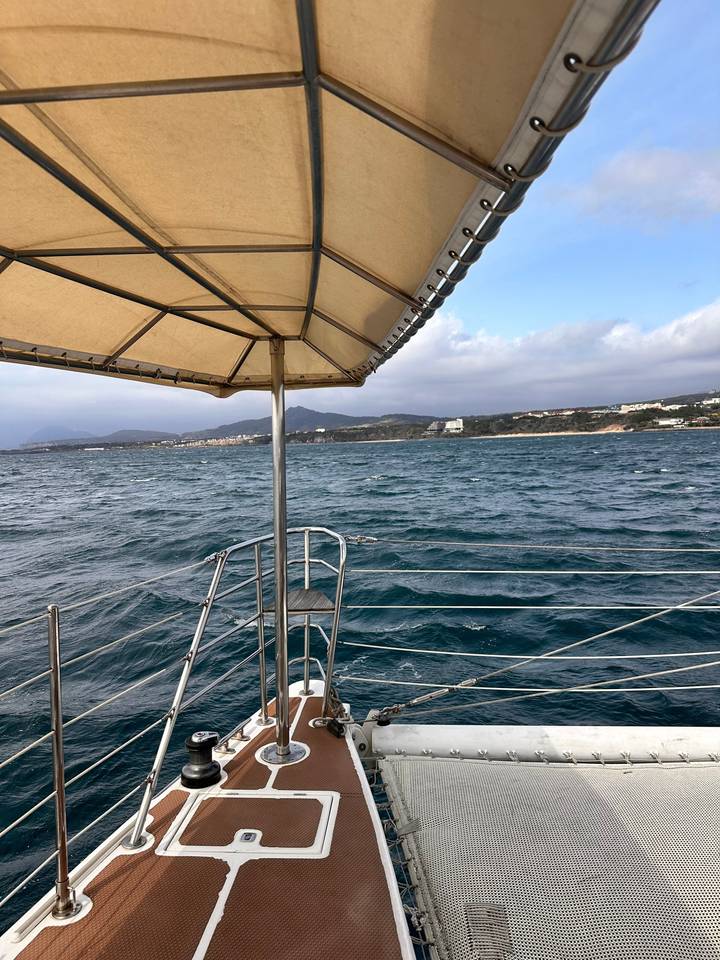 Rambarde de bateau avec vue sur la mer et le littoral.