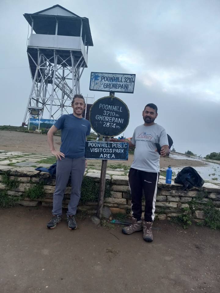 Zwei Personen posieren mit Schildern am Poon Hill