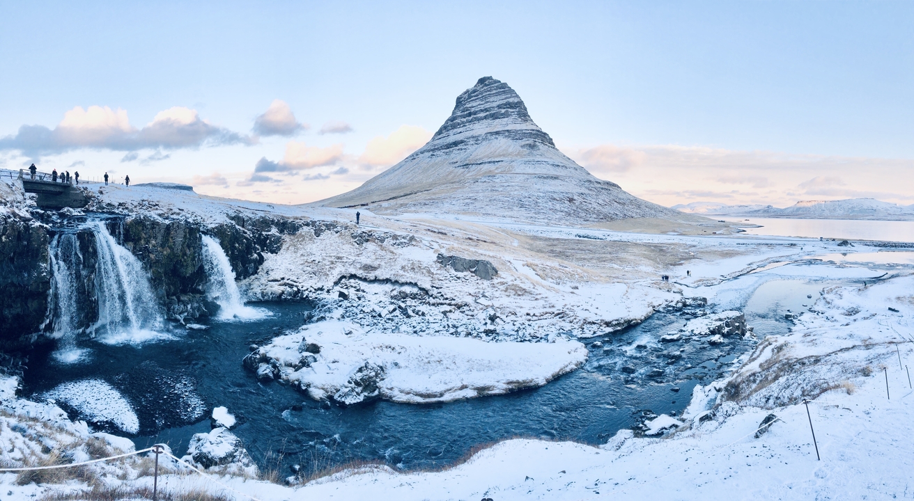 Snowy landscape with a mountain and waterfall.