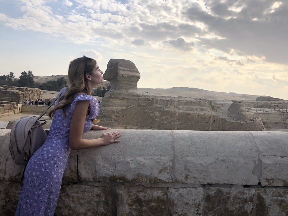 Woman pretending to kiss the Sphinx in Egypt.