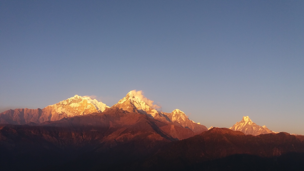 Série de montagnes au coucher du soleil aux teintes chaudes.