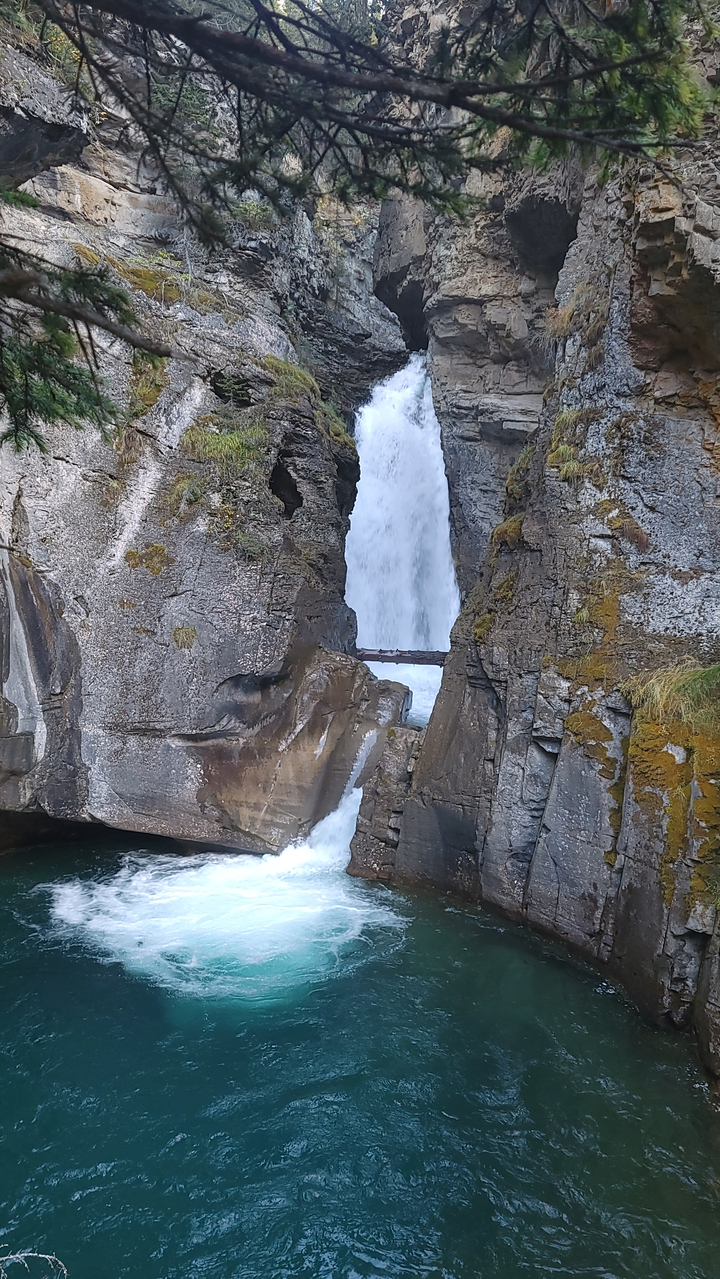 Waterfall flowing between rocky cliffs.