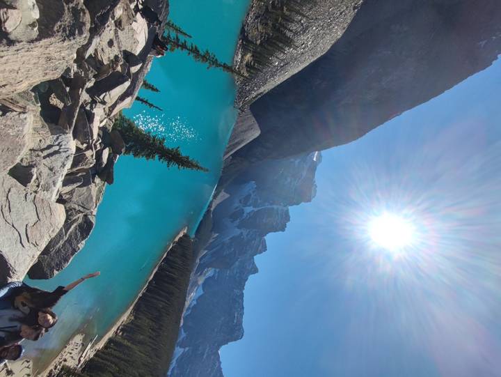 Turquoise lake surrounded by mountains on a sunny day.