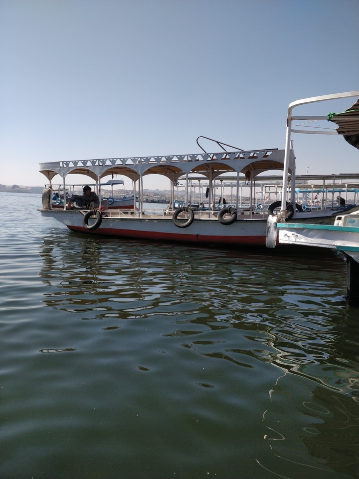 Boats docked at the water's edge on a sunny day.