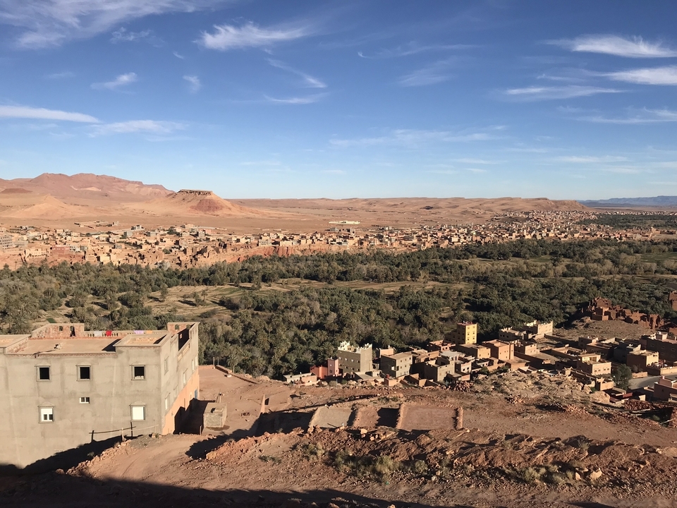 Expansive view of a village and desert under blue skies.