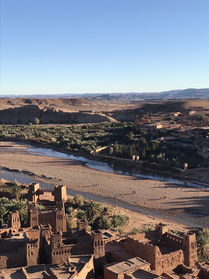 Aerial view of a river weaving through a desert village.