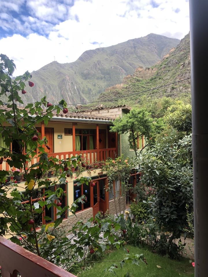 Maison rustique avec des fleurs dans un paysage montagneux.