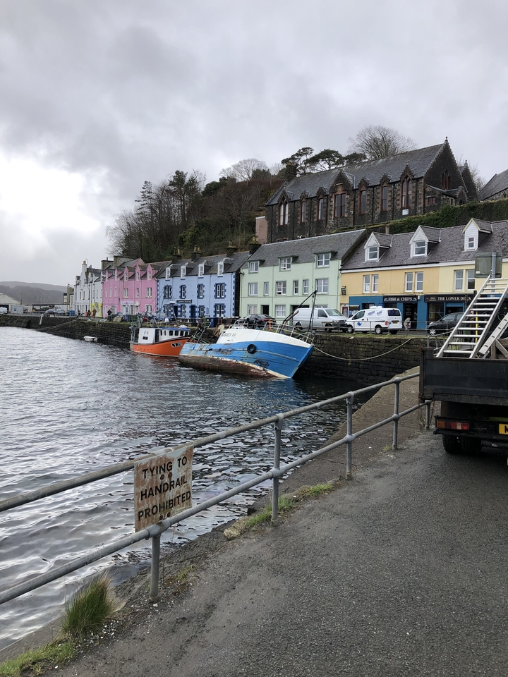Colorful buildings and boats along a waterfront, with a small harbor.