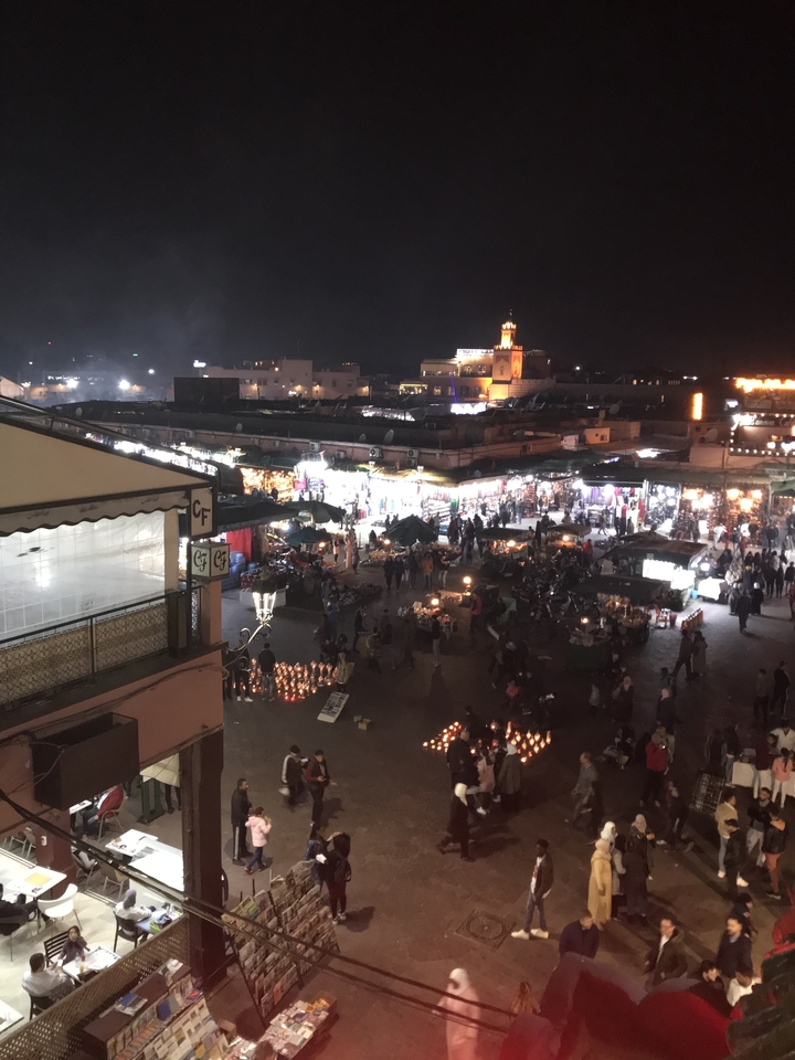 Crowded night market with lit stalls and people.