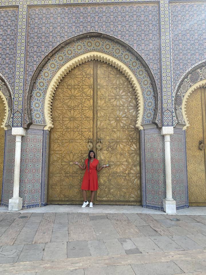 Person standing in front of an ornate golden door.