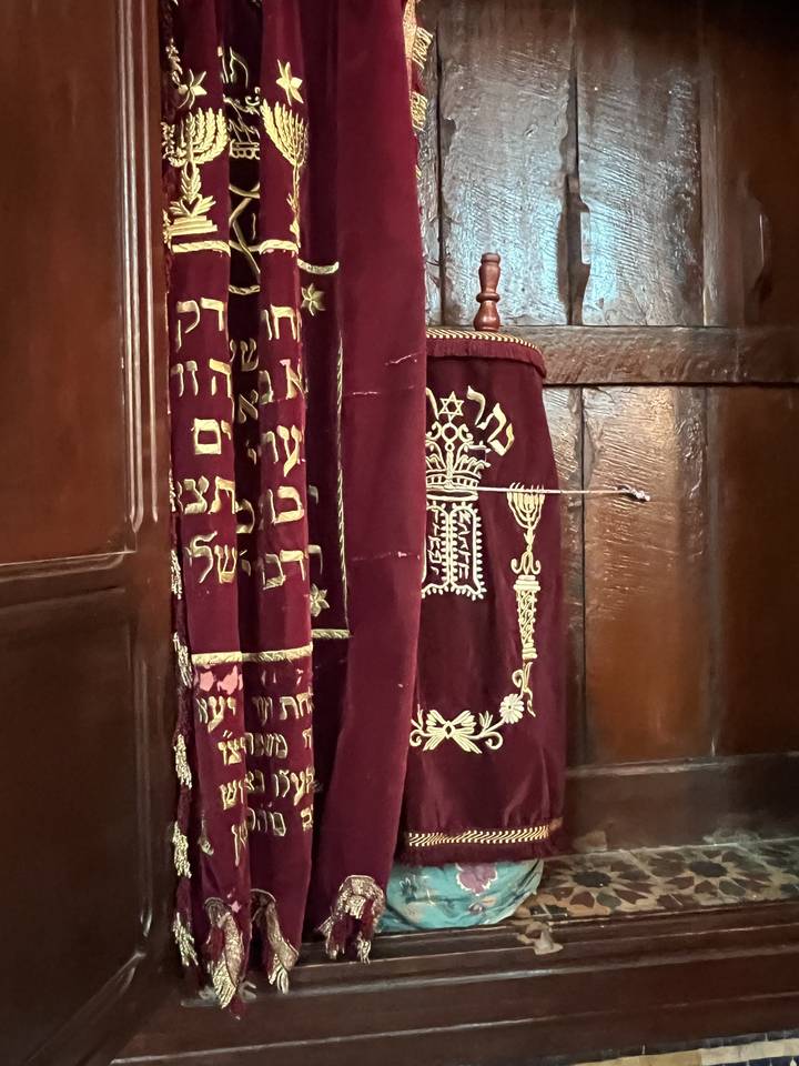 Close-up of traditional embroidered fabric with Arabic text.