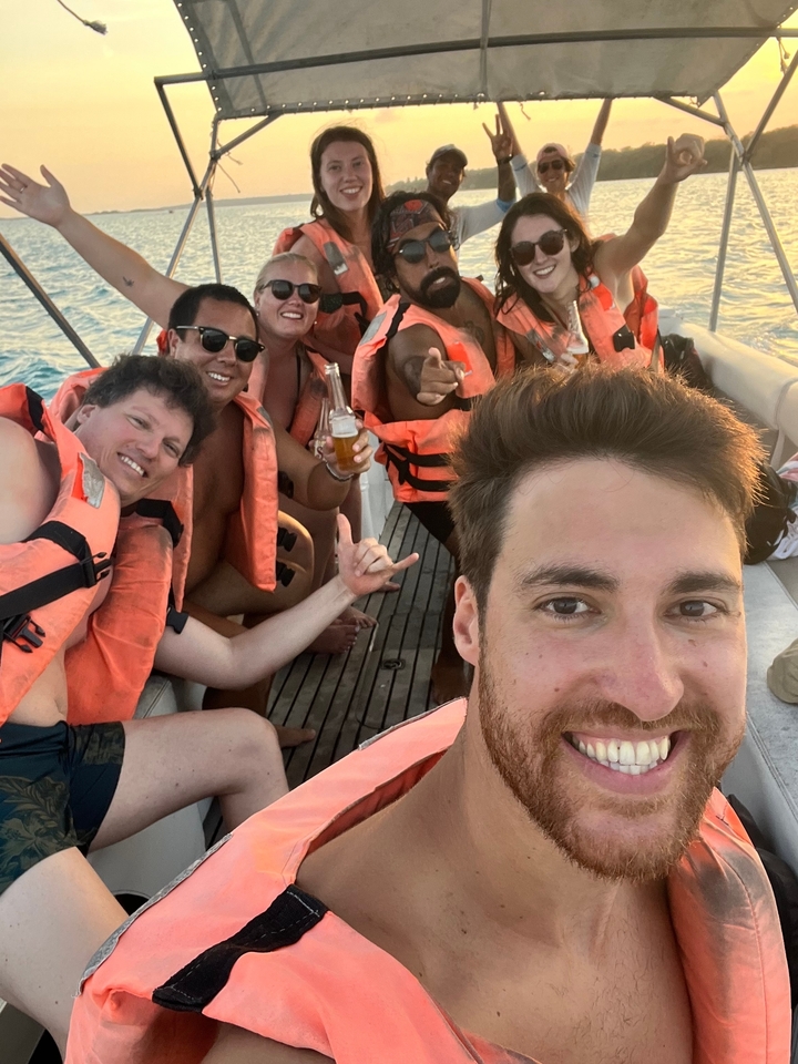 Group of friends on a boat wearing life vests.