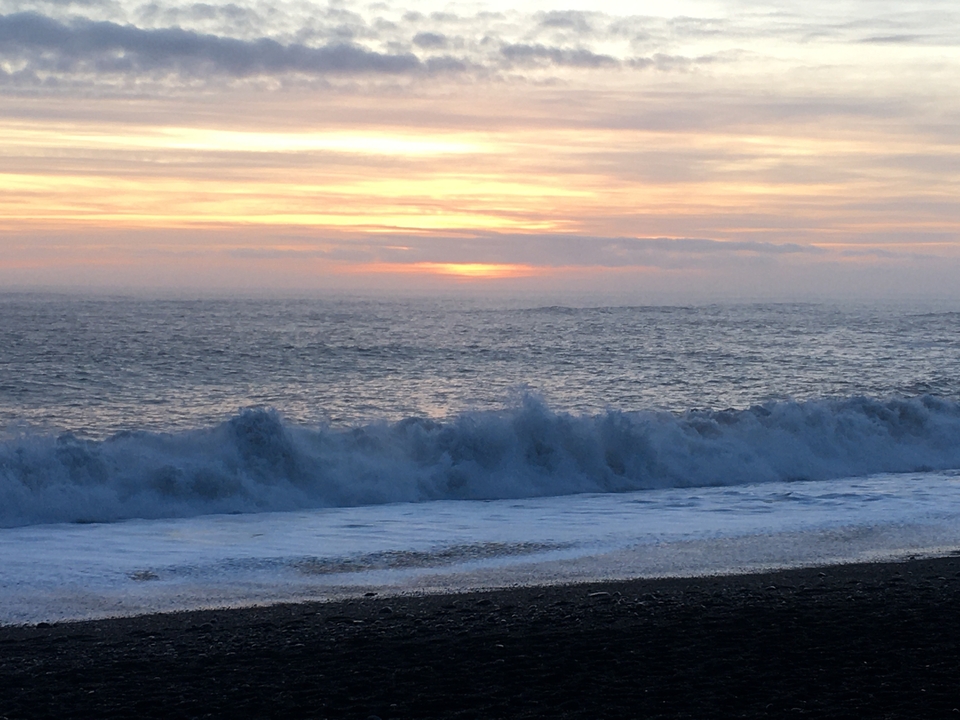 A scenic view of ocean waves with a sunset in the background.