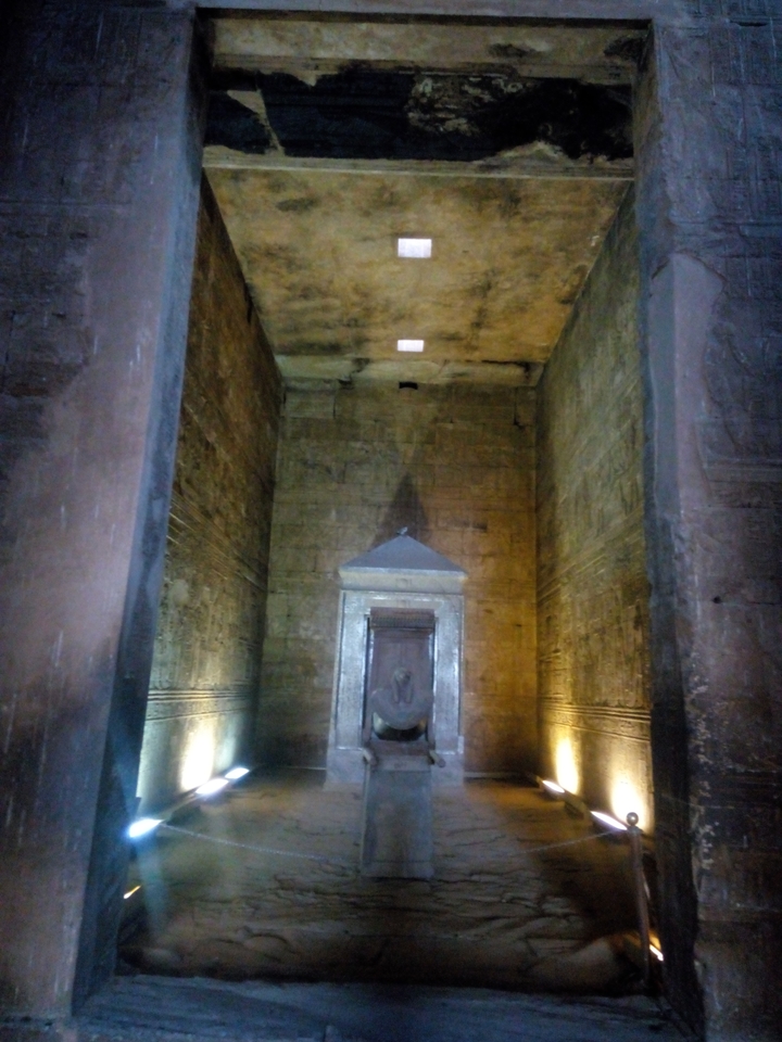 Un intérieur d'un temple antique ou d'un tombeau avec des inscriptions sur les murs.