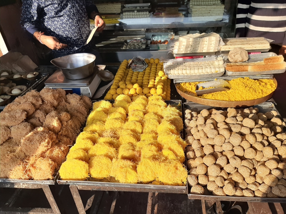 Présentation de diverses sucreries indiennes colorées.