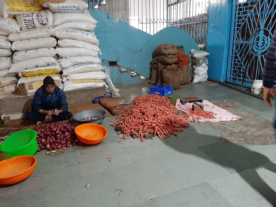 Homme vendant des légumes dans un marché.