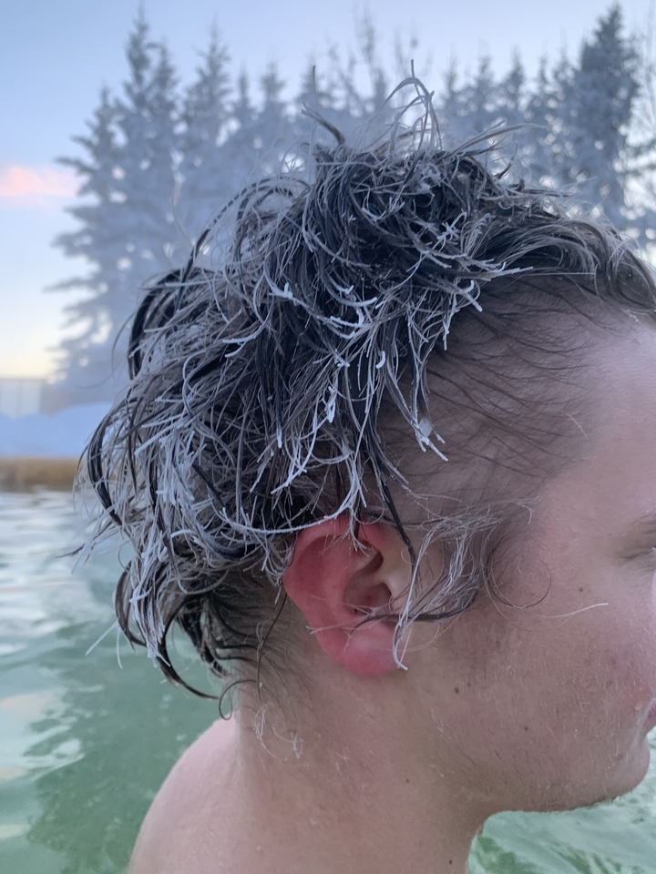 Close-up of a person's frosted hair in a hot spring.