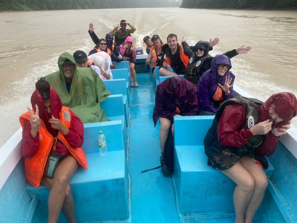 Des gens sur un bateau profitant d'un voyage sur la rivière sous un ciel nuageux.