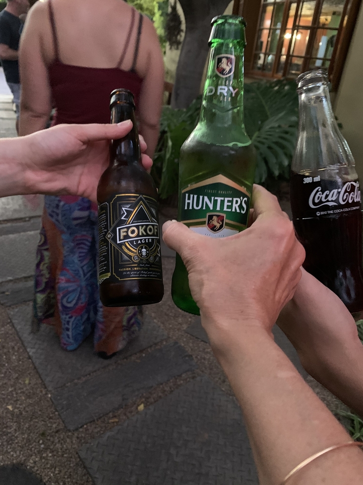 Close-up of hands holding beverages including beer.