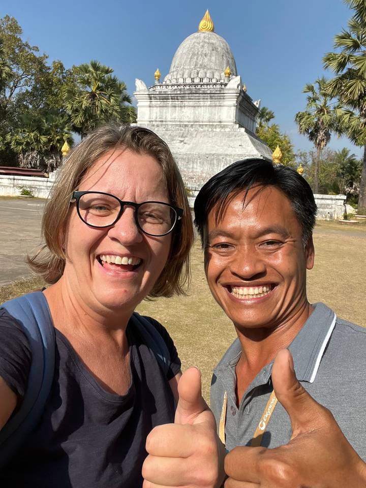 Deux personnes souriantes avec un stupa en arrière-plan