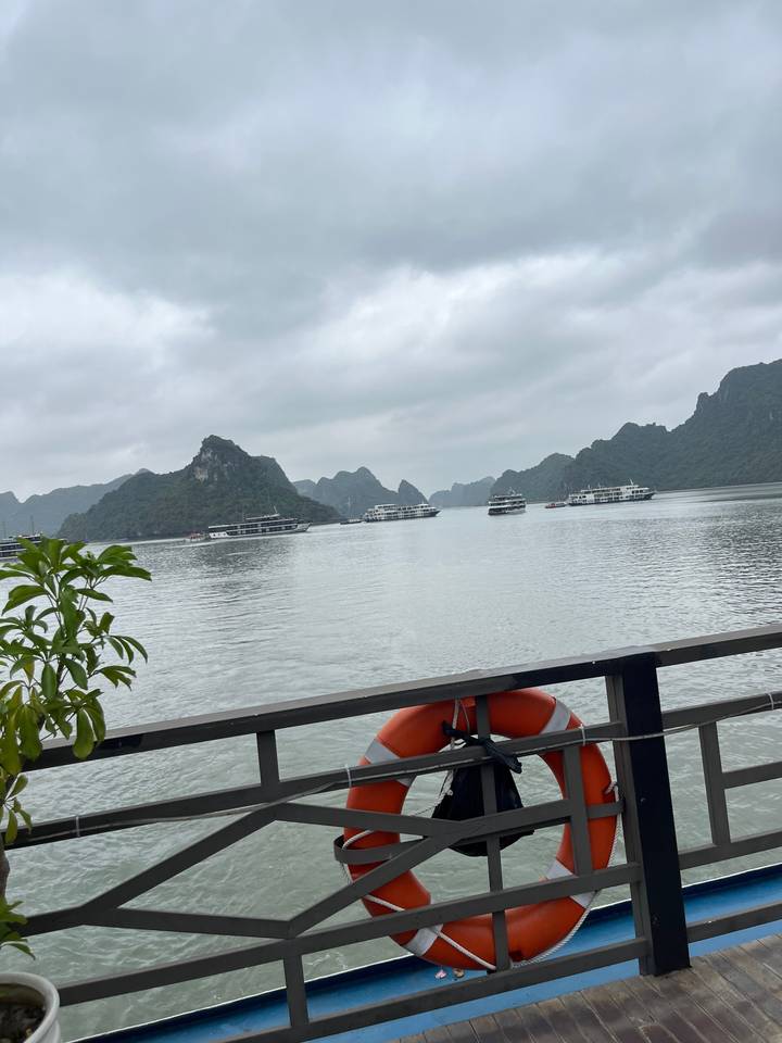 Vue sur la rivière avec bouée de sauvetage fixée à une rambarde, entourée de montagnes.