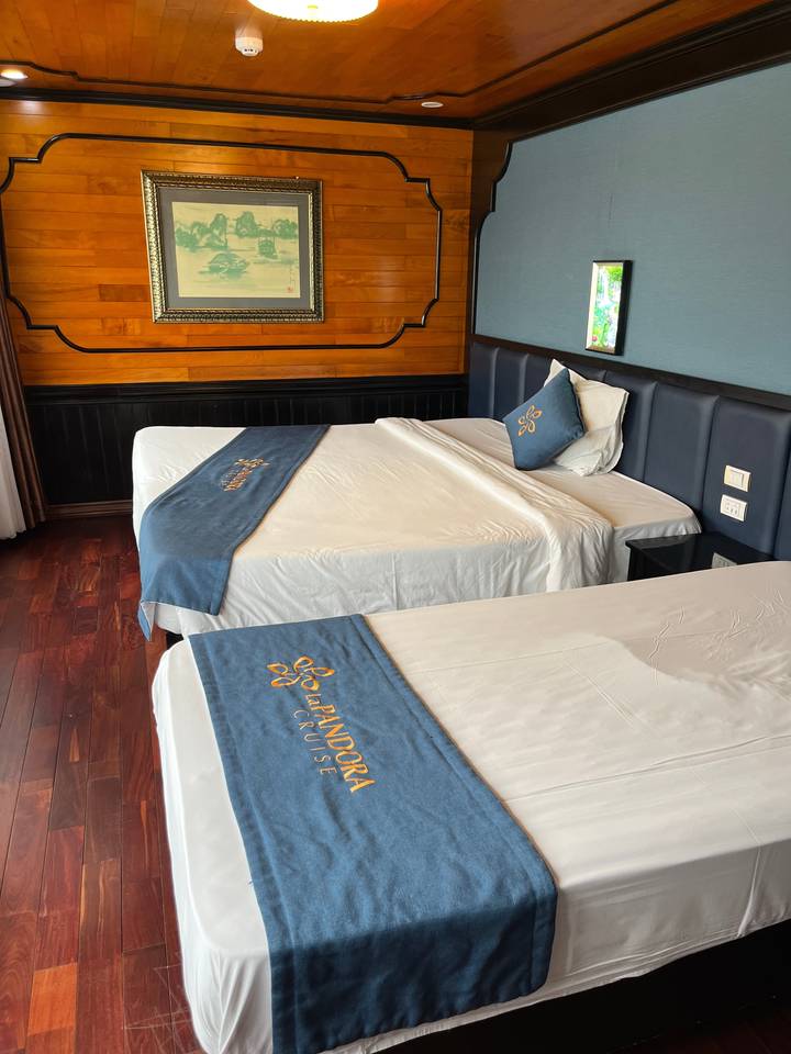 Intérieur de cabine avec un lit orné de linge de lit « Pandora Cruise ».