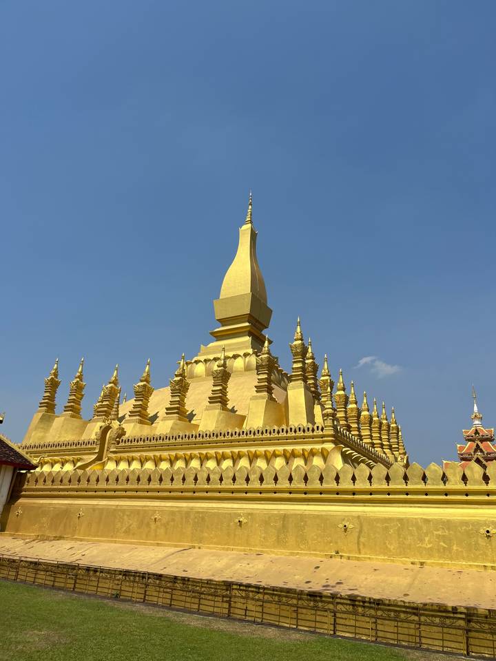 Temple doré avec plusieurs niveaux d'architecture décorative vu depuis le sol.