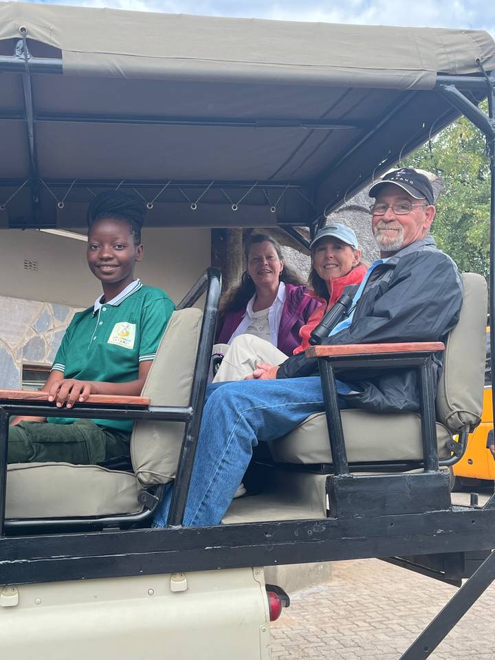 Group of people seated in a safari vehicle.