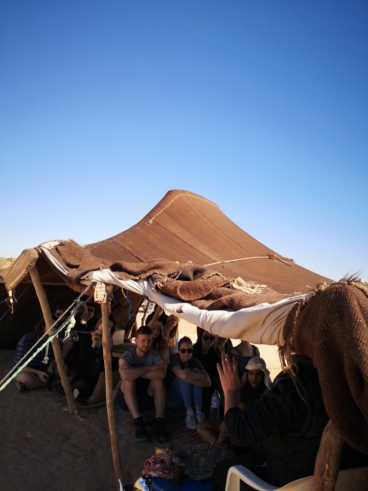 Tent under the blue sky with people.