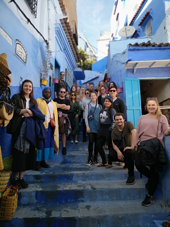 Group of people posing on blue steps.