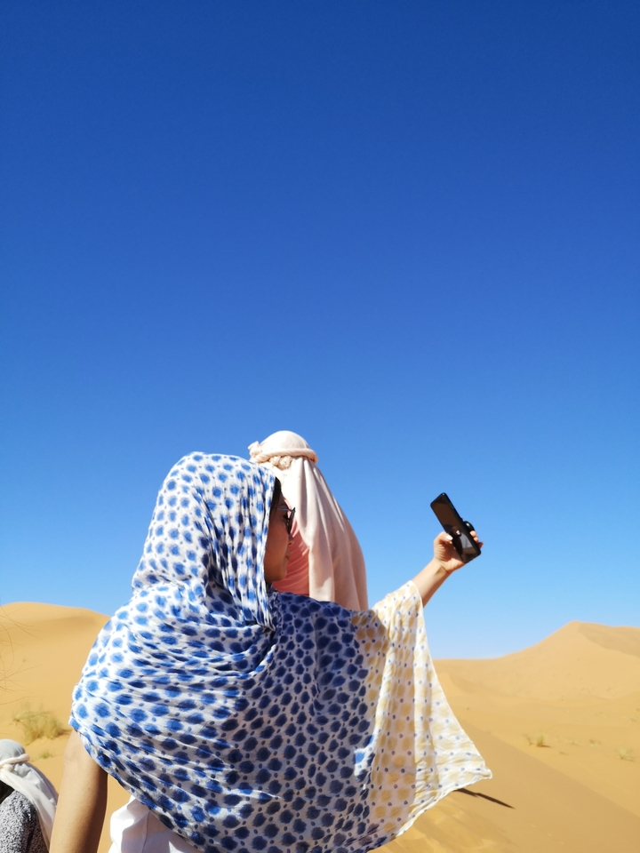 Person with a blue scarf taking a selfie.