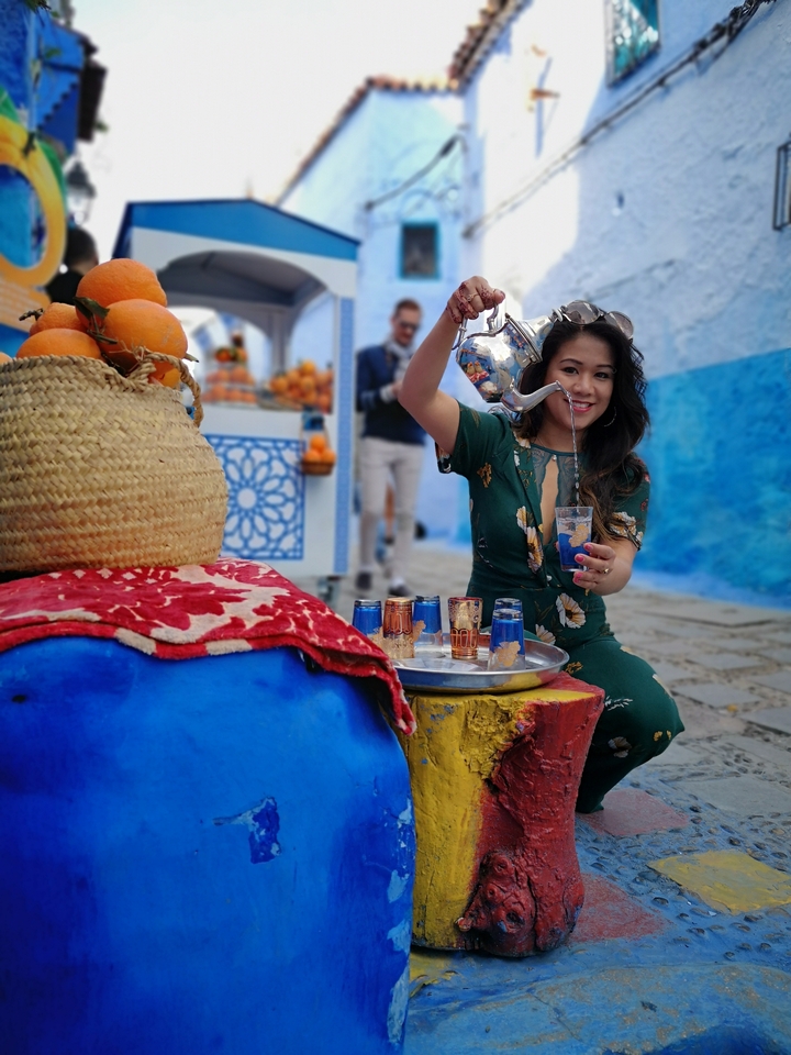 Person pouring tea from a kettle.