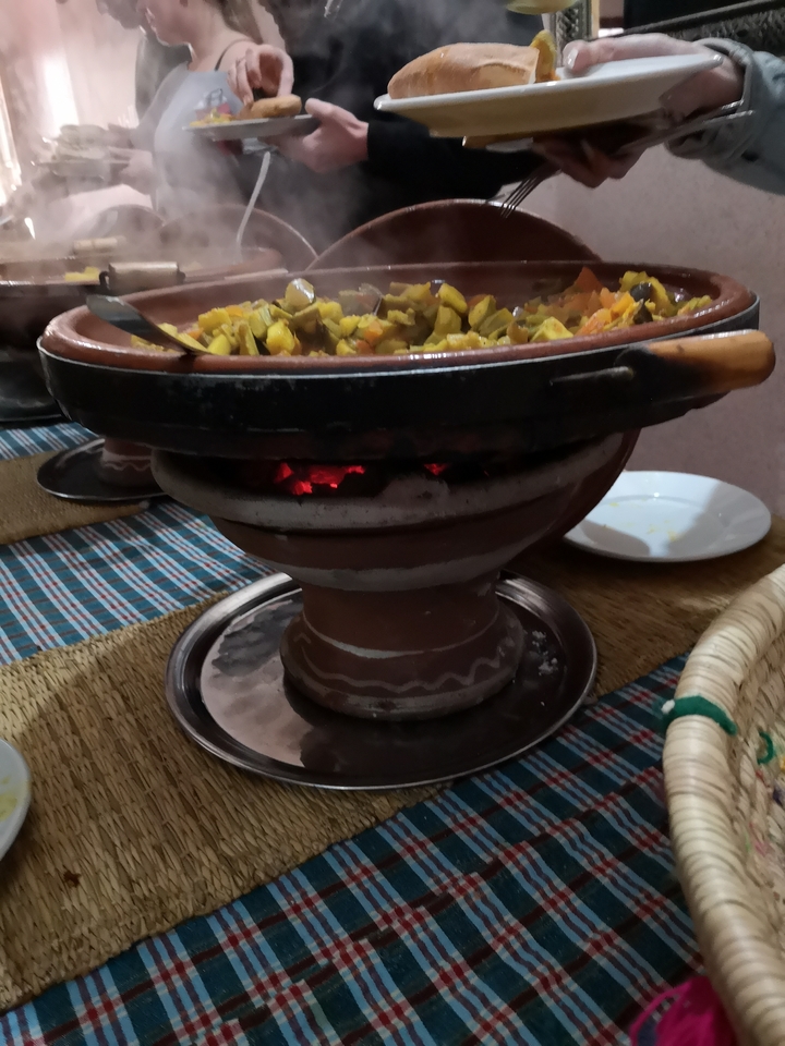 Clay pot with fire underneath cooking food.