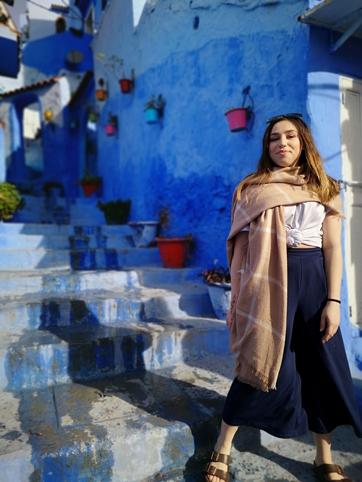 Person standing in a blue alleyway.