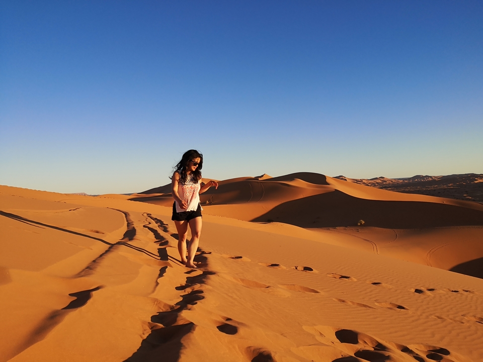 Person walking on sand dunes.