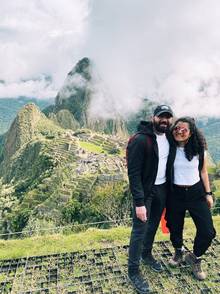 Two people smiling with Machu Picchu background.