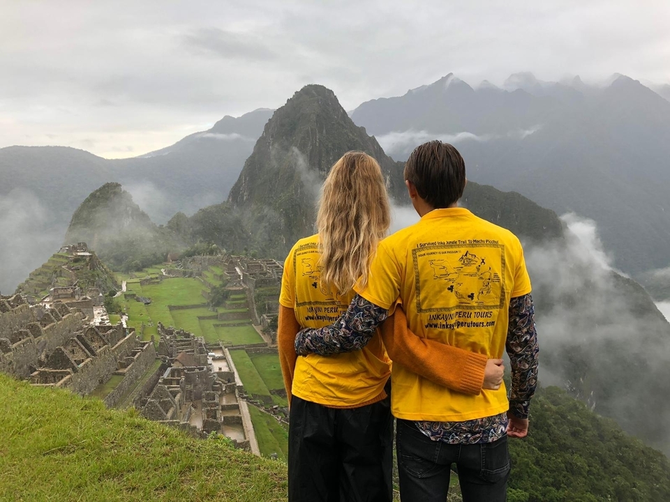 Couple in matching shirts overlooking Machu Picchu.