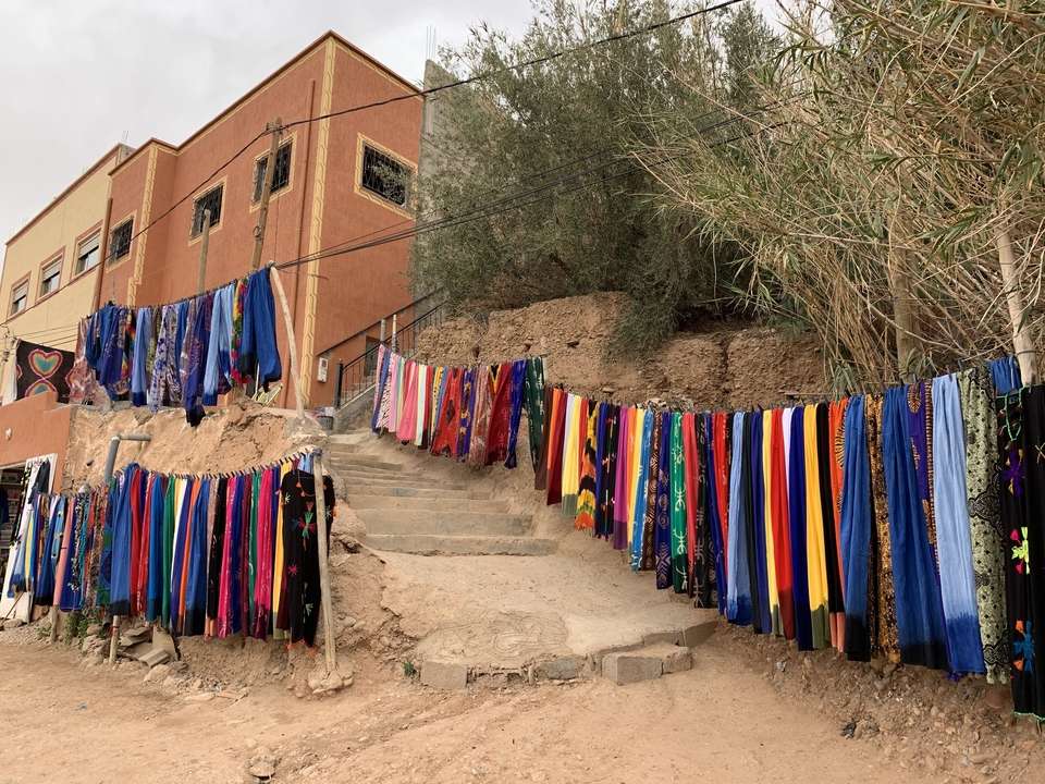 Vibrant display of scarves hung along a street.