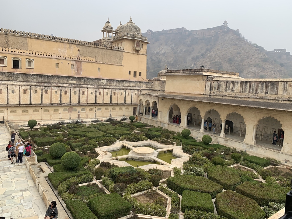 Inner courtyard of a historical fort with gardens and visitors.