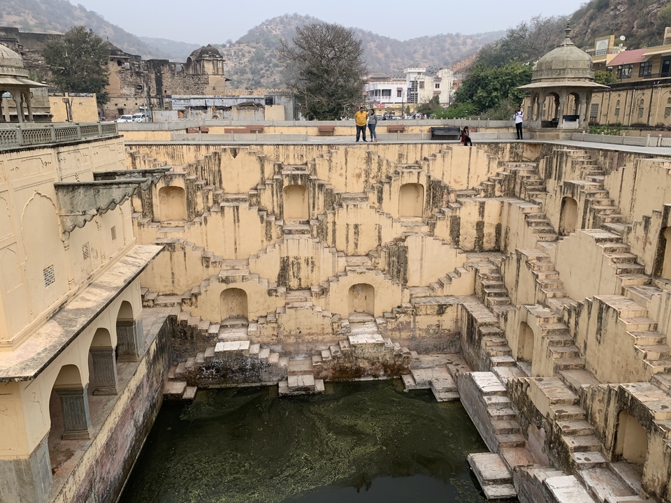 Stepwell structure with intricate steps and visitors.