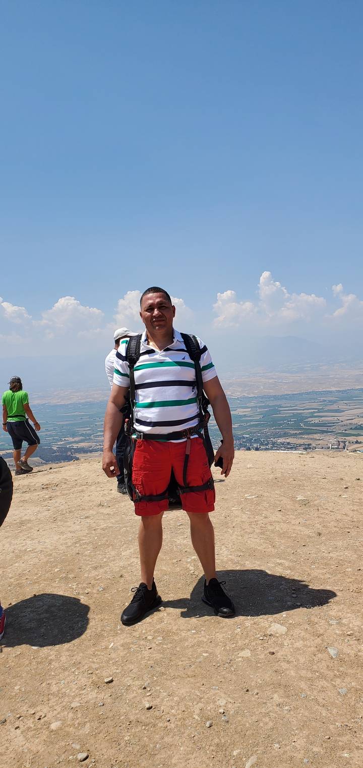 Person standing on a hill with a scenic view.