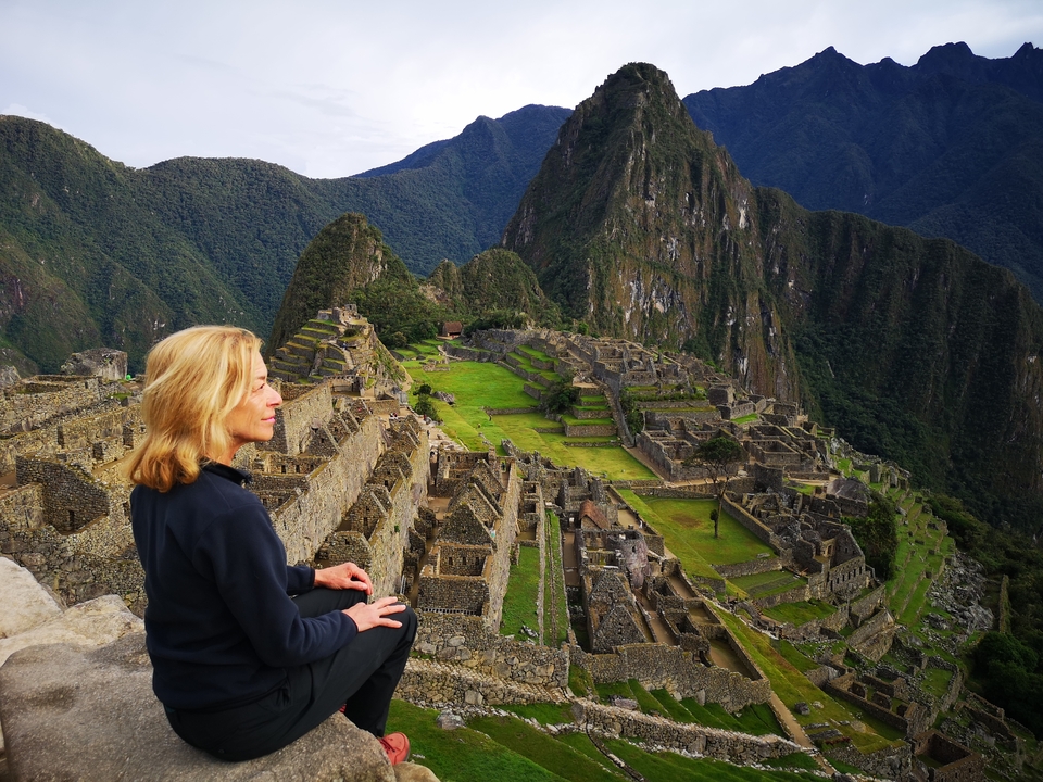 Panoramic view of Machu Picchu with a woman looking on.