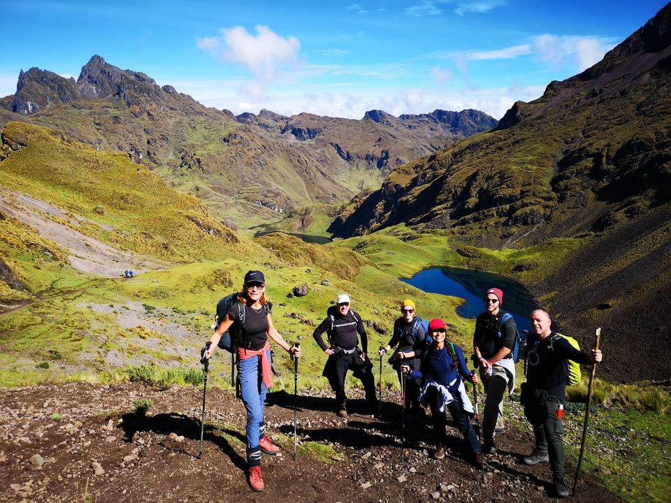 Hikers posing with a scenic mountain landscape in the background.