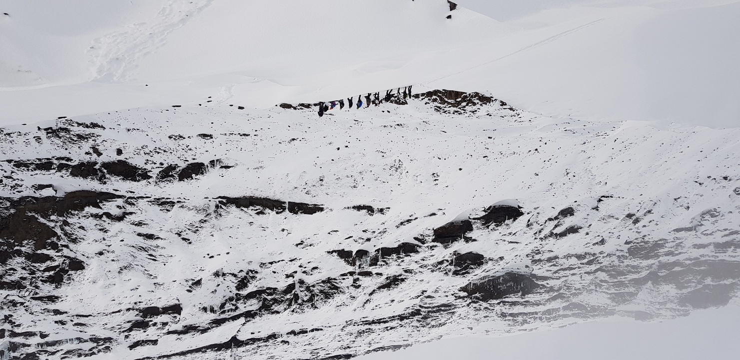 Snow-covered landscape with small flags visible on a hill.