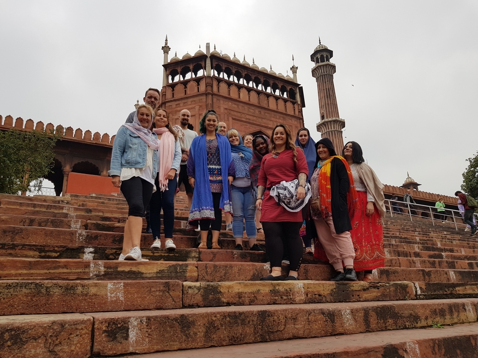 Group posing on stairs with historical building in the background.